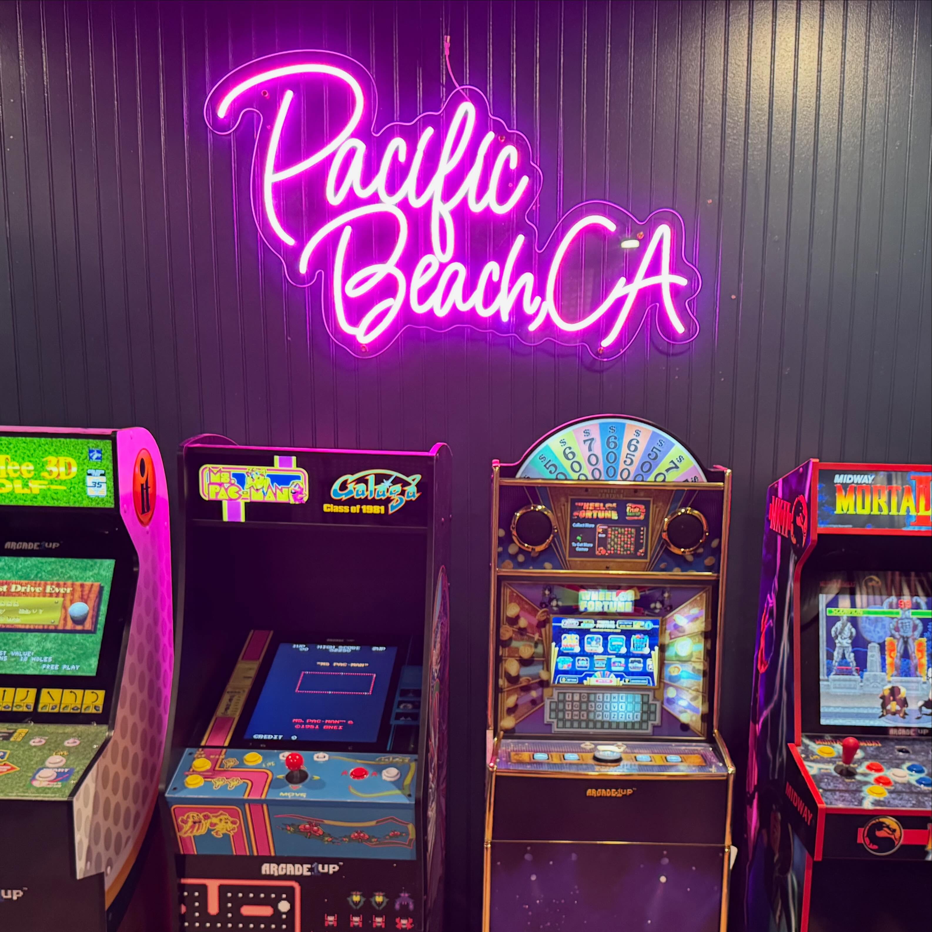 Real Pacific Beach pink neon installation above arcade game cabinets